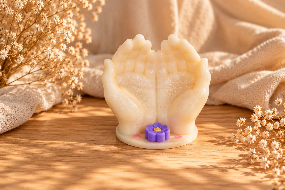 Bougie mains ouvertes crème avec une petite fleur violette